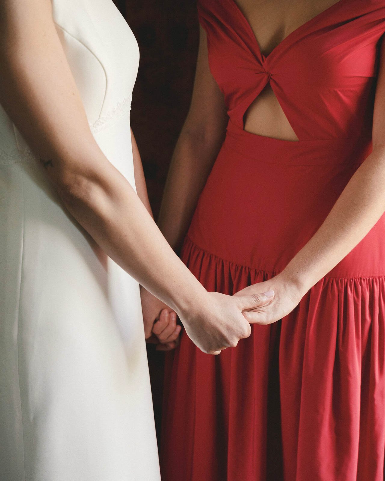 detalle de manos unidas con vestido rojo y blanco