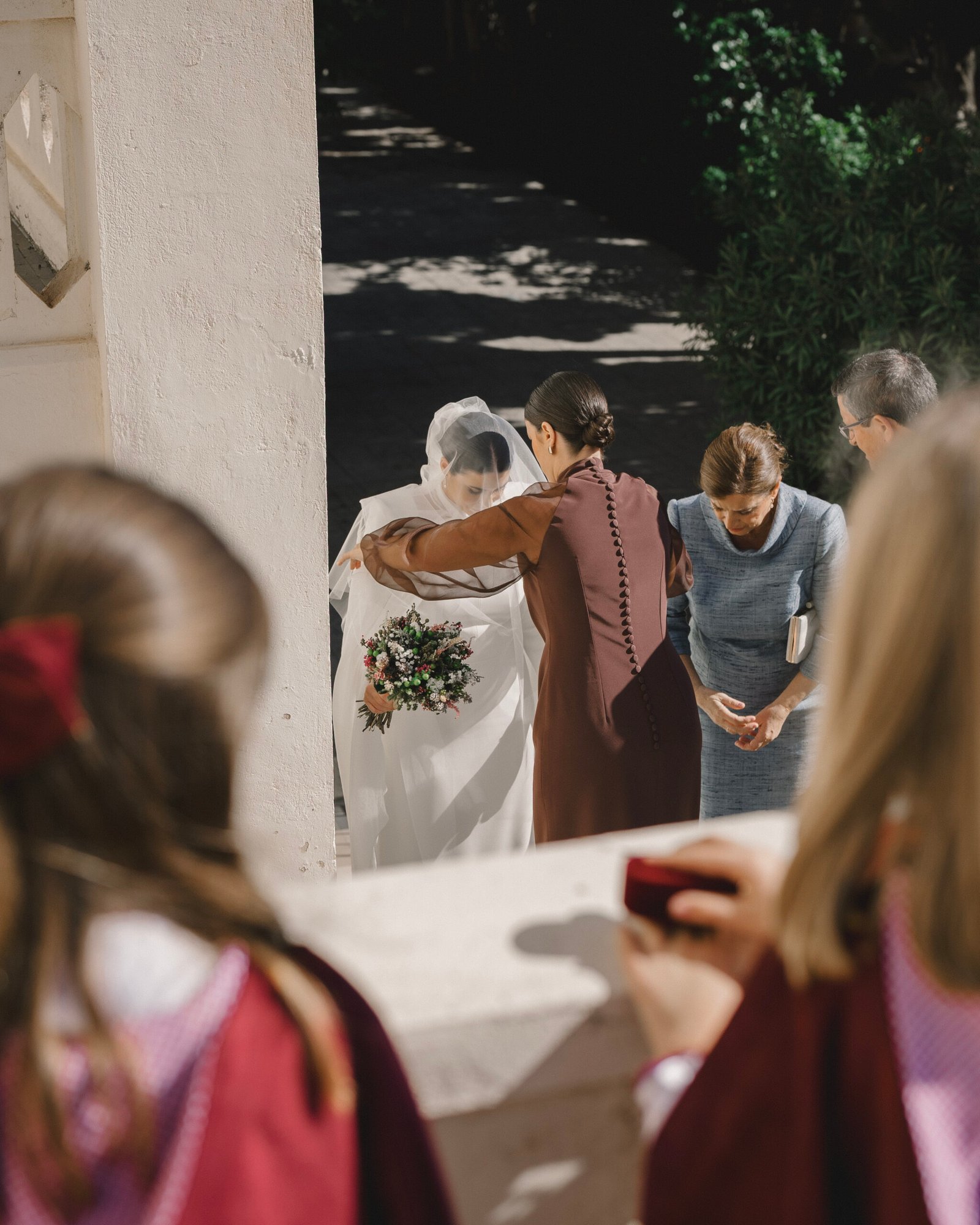 novia preparando su velo antes de entrar en la iglesia