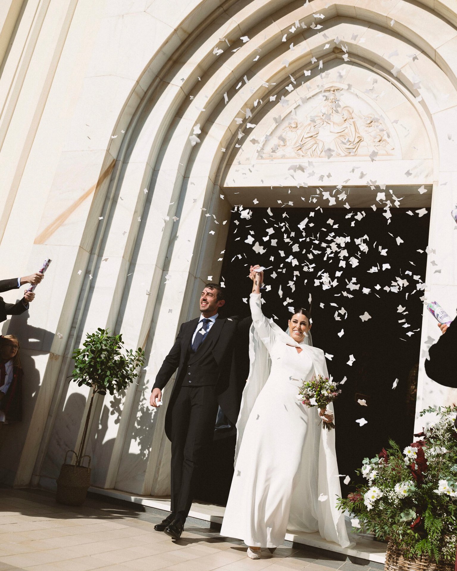 salida de una iglesia con pétalos en el aire